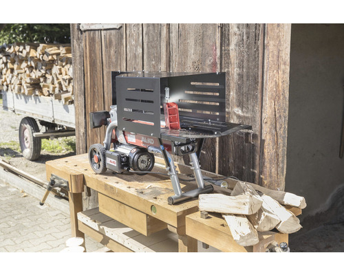 Štiepačka na drevo na pracovnom stole pred drevenou stenou