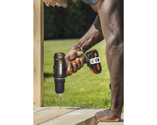 Muž vŕta akumulátorovým skrutkovačom otvor do drevenej dosky.