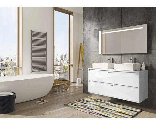 Svetlá kúpeľňa s vaňou, rebríkovým radiátorom, umývadlovou skrinkou s dvoma umývadlami a osvetleným zrkadlom.