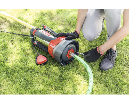 Osoba pripevňuje záhradnú hadicu k hlbinnému čerpadlu AL-KO na trávniku.