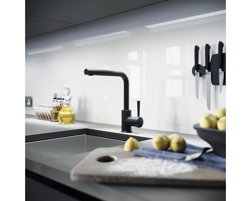 Moderná kuchyňa s čiernou vodovodnou batériou, drezom a kuchynskými potrebami