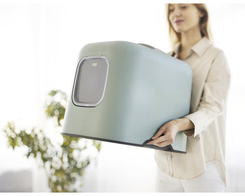 Žena drží mačaciu toaletu s vekom a okienkom