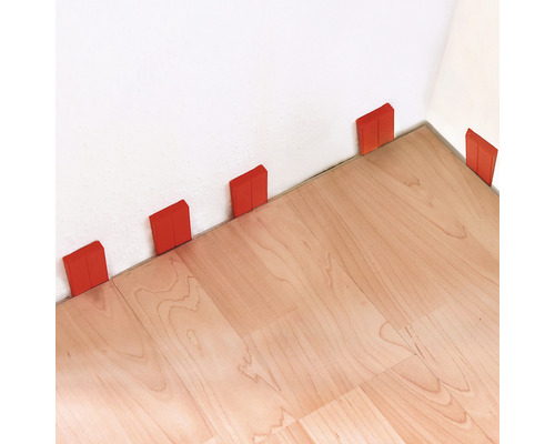 Ukladanie laminátu s dištančnými klinmi pri stene