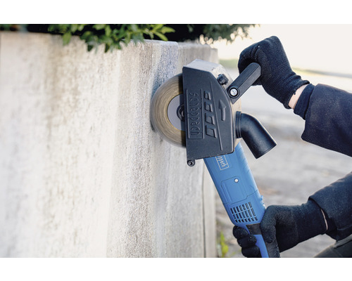 Osoba používa drážkovaciu frézu Scheppach na úpravu betónovej steny.
