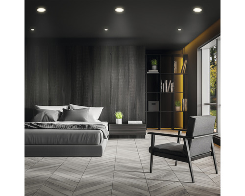 Spálňa s posteľou, kreslom a knižnicou v tmavom prevedení