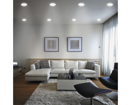 Obývacia izba so stropnými svetlami, pohovkou, kobercom a dekoráciami