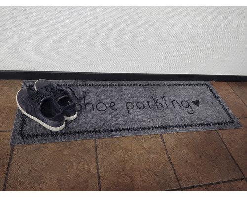 Rohožka s nápisom parkovisko topánok a topánky na nej