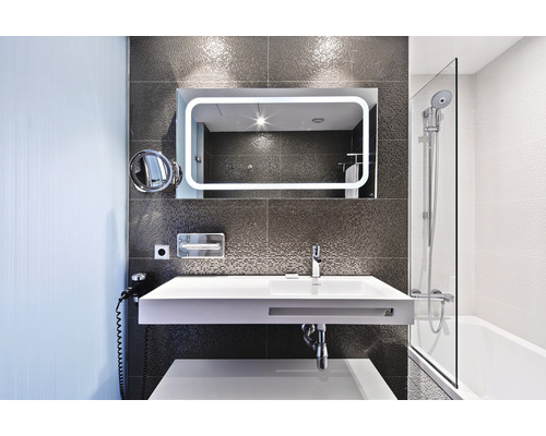 Moderná kúpeľňa s umývadlom, zrkadlom s osvetlením a vaňou so sprchovacou zástenou