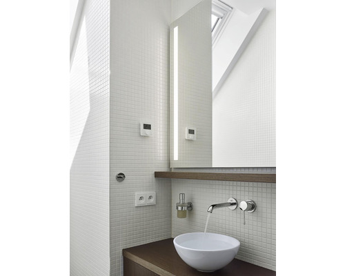 Moderná kúpeľňa s mozaikovými obkladmi, umývadlom a osvetleným zrkadlom