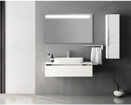 Moderná kúpeľňa s bielym umývadlom, osvetleným zrkadlom a vysokou skriňou.