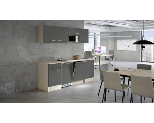 Kancelárska kuchyňa s umývačkou riadu, mikrovlnnou rúrou a jedálenským stolom vo svetlej kancelárskej miestnosti.