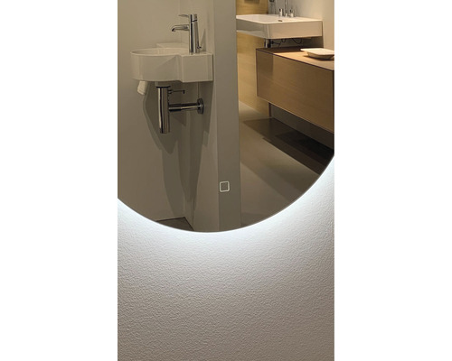 Detail kúpeľne s okrúhlym zrkadlom s LED osvetlením, umývadlom a batériou