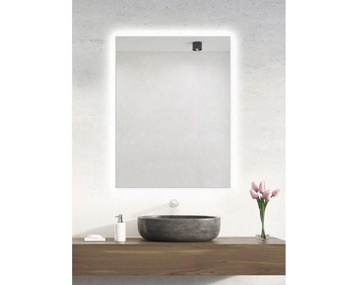 Kúpeľňa s osvetleným zrkadlom, umývadlom a kyticou