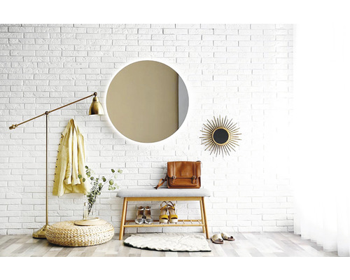 Vstupný priestor so zrkadlom, lavicou, stojacou lampou a dekoráciami pred bielou tehlovou stenou