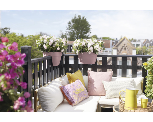 Zdobená balkónová scéna s kvetináčmi, vankúšmi a sedením