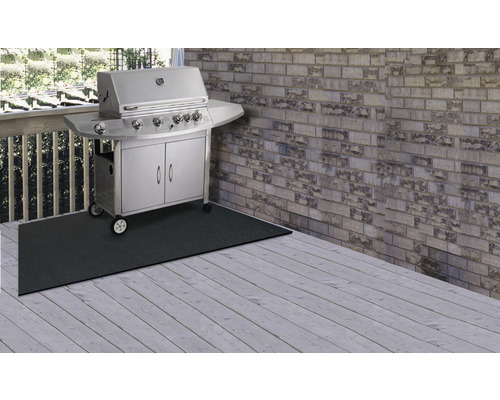 Scéna s plynovým grilom na ochrannej podložke na drevenej terase.