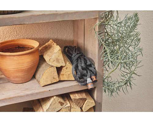 Polica so záhradnou hadicou, drevenými briketami, kvetináčom a rastlinou