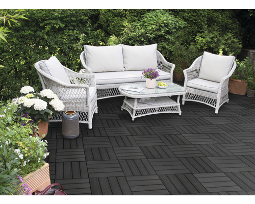 Terasa s tmavými terasovými dlaždicami a ratanovým posedením v záhrade