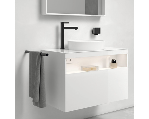 Moderná kúpeľňa s bielou umývadlovou skrinkou, umývadlom na dosku, čiernou batériou a držiakom na uteráky.