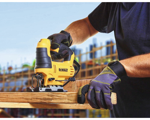 Priamočiara píla reže drevenú dosku, obsluhuje ju osoba v pracovných rukaviciach