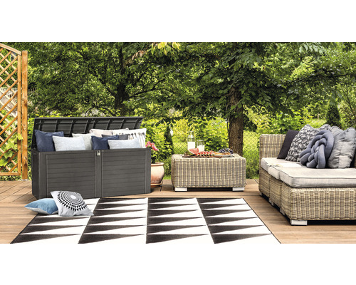 Záhradná scéna s boxom na podušky, stolom, pohovkou a kobercom na drevenej terase