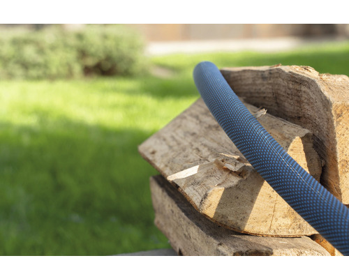 Záhradná hadica na hromade dreva v záhrade