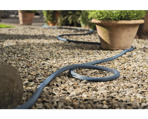 Ohybná záhradná hadica na štrkovom povrchu vonku.