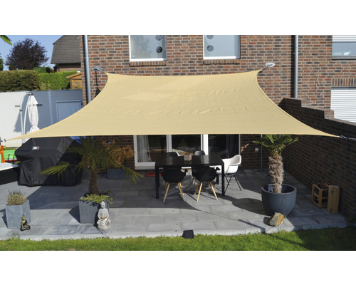 Terasa so slnečnou plachtou, stolom a stoličkami pred domom