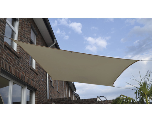 Béžová slnečná clona na tehlovej budove s modrou oblohou