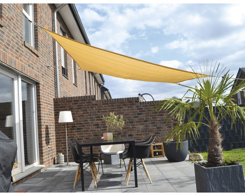 Terasa so slnečnou plachtou, stolom a stoličkami pred domom