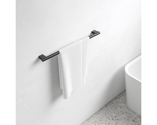 Čierny držiak na uteráky s bielym uterákom v kúpeľni
