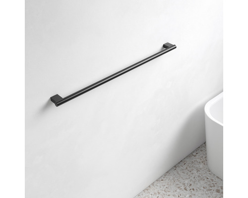 Čierny držiak na uteráky na bielej stene v kúpeľni.