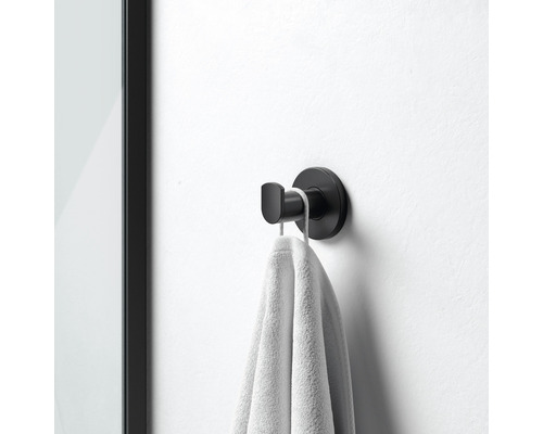 Čierny háčik na uteráky s uterákom namontovaným na stene