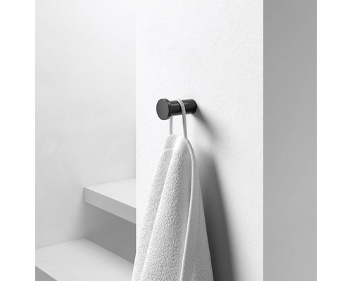 Čierny háčik na uteráky s uterákom na stene