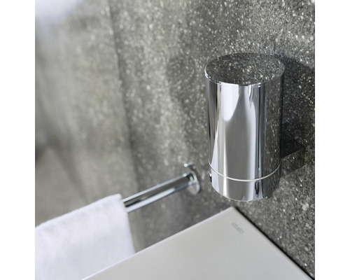 Nástenný držiak na zubnú kefku a držiak na uteráky z kovu v kúpeľni.