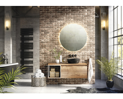 Moderná kúpeľňa s umývadlom, zrkadlom, radiátorom na uteráky a vaňou pred tehlovou stenou