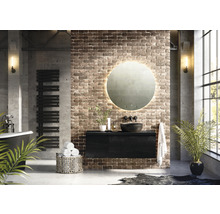 Moderná kúpeľňa s voľne stojacou vaňou, radiátorom na uteráky, skrinkou pod umývadlo, okrúhlym zrkadlom s osvetlením a tehlovou stenou