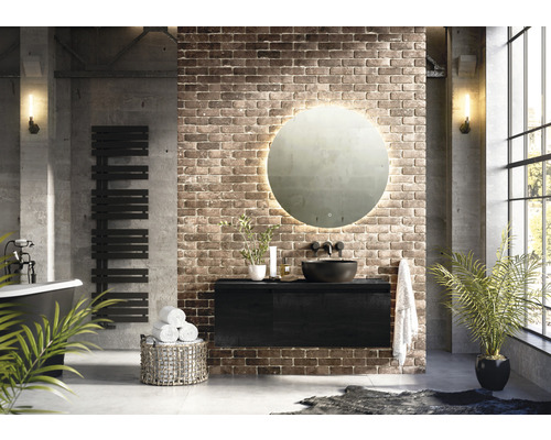 Moderná kúpeľňa s voľne stojacou vaňou, radiátorom na uteráky, skrinkou pod umývadlo, okrúhlym zrkadlom s osvetlením a tehlovou stenou