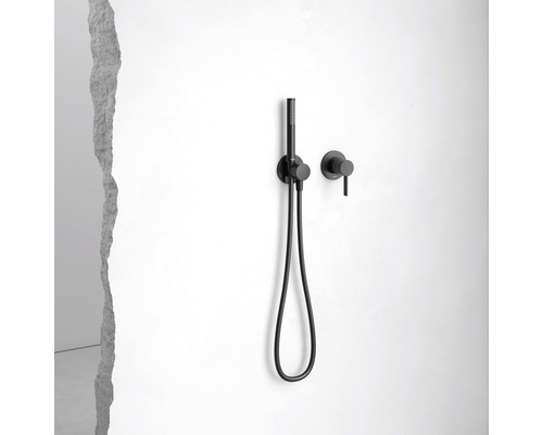 Čierna ručná sprcha s hadicou a nástennou armatúrou na bielej stene