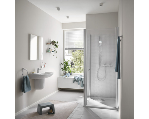 Svetlá kúpeľňa so sprchou, umývadlom a oknom pre priateľské prostredie