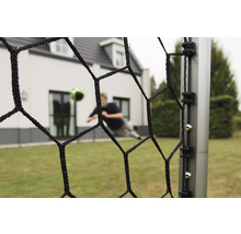 Futbalová bránka so sieťou a futbalistom v pozadí