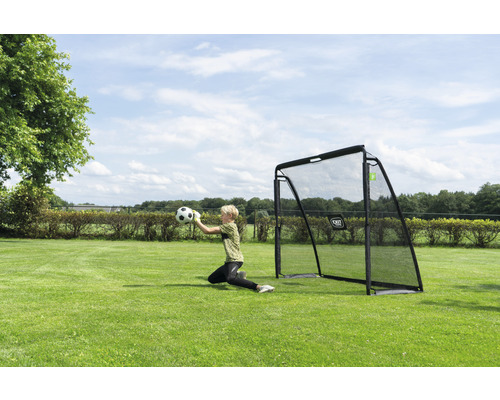 Vonkajšia scéna s futbalovou bránkou a brankárom chytajúcim loptu na trávniku.