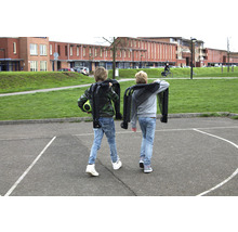 Dve deti nesú zložené vozíky na školskom dvore.