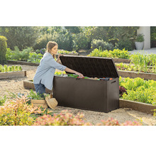 Záhradná scéna so ženou otvárajúcou záhradný box vonku a vyberajúcou záhradné náradie