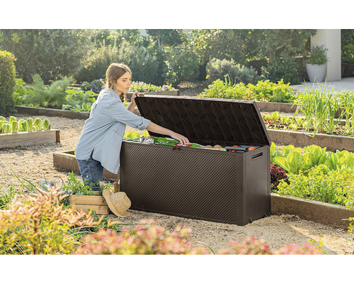 Záhradná scéna so ženou otvárajúcou záhradný box vonku a vyberajúcou záhradné náradie