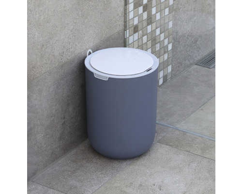 Kúpeľňová scéna s okrúhlym plastovým odpadkovým košom s vekom