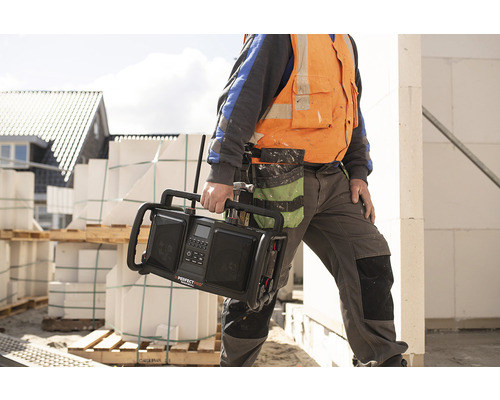 Stavebný robotník nesie staveniskové rádio značky Perfectpro.