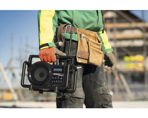 Remeselník drží staveniskové rádio značky Perfectpro.