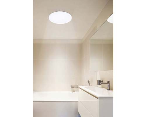 Kúpeľňa s vaňou, umývadlom a okrúhlym stropným svietidlom