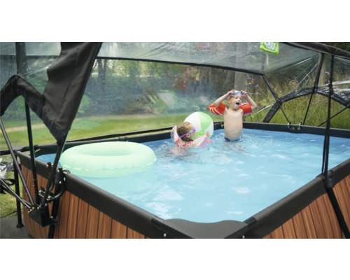 Bazén so strechou, deti sa hrajú s plávacím kolesom a loptou vo vode